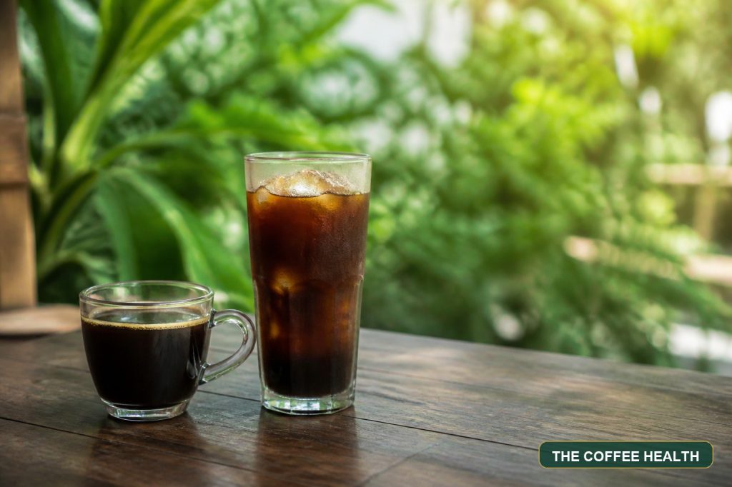Americano nóng và Americano đá trên bàn gỗ trong không gian xanh